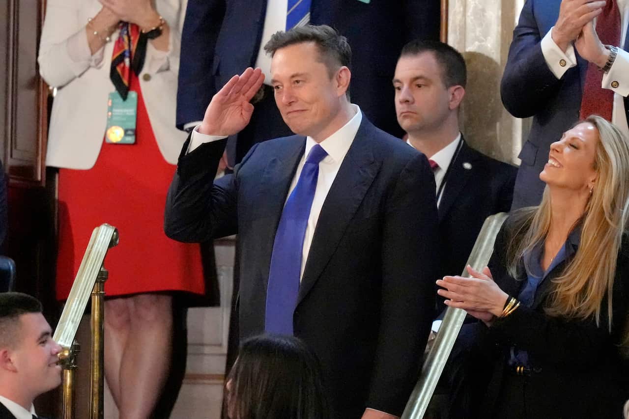 a man in a suit smiling while saluting