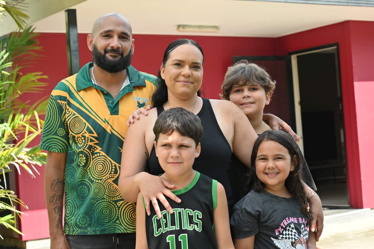 The Liddle family with three of their four children outside their new home