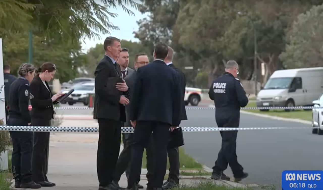 Police officers and investigators at a crime scene sealed off with police tape.