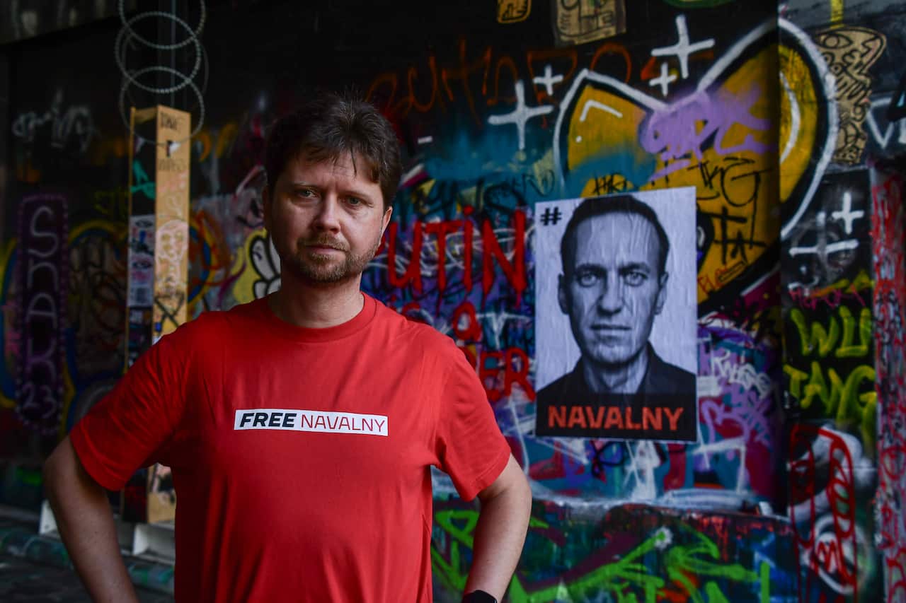 A man wearing a red top with a logo that reads: "FREE NAVALNY".