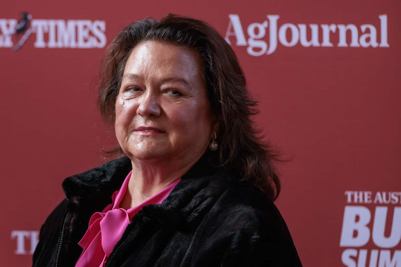 A woman wearing a bright pink shirt and black jacket