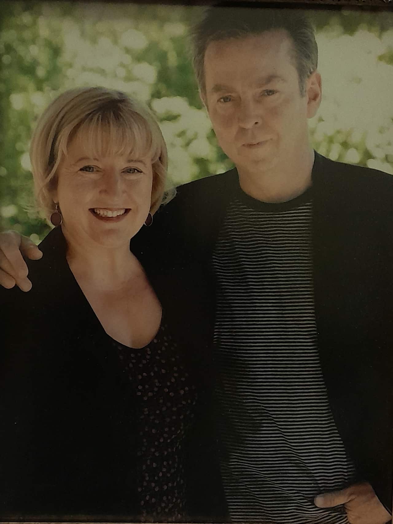 A woman and a man standing next to each other and smiling.