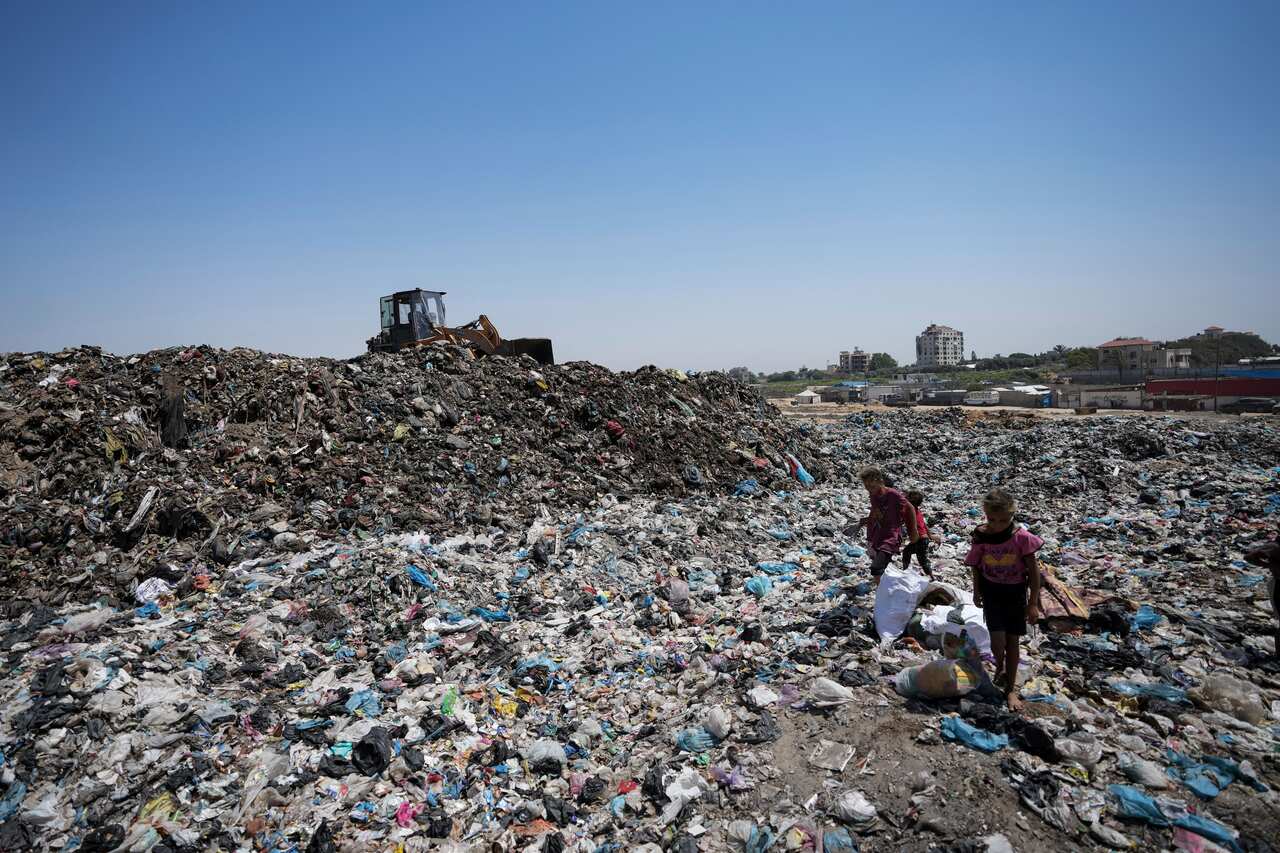 Young people sorting through trash at a landfill.