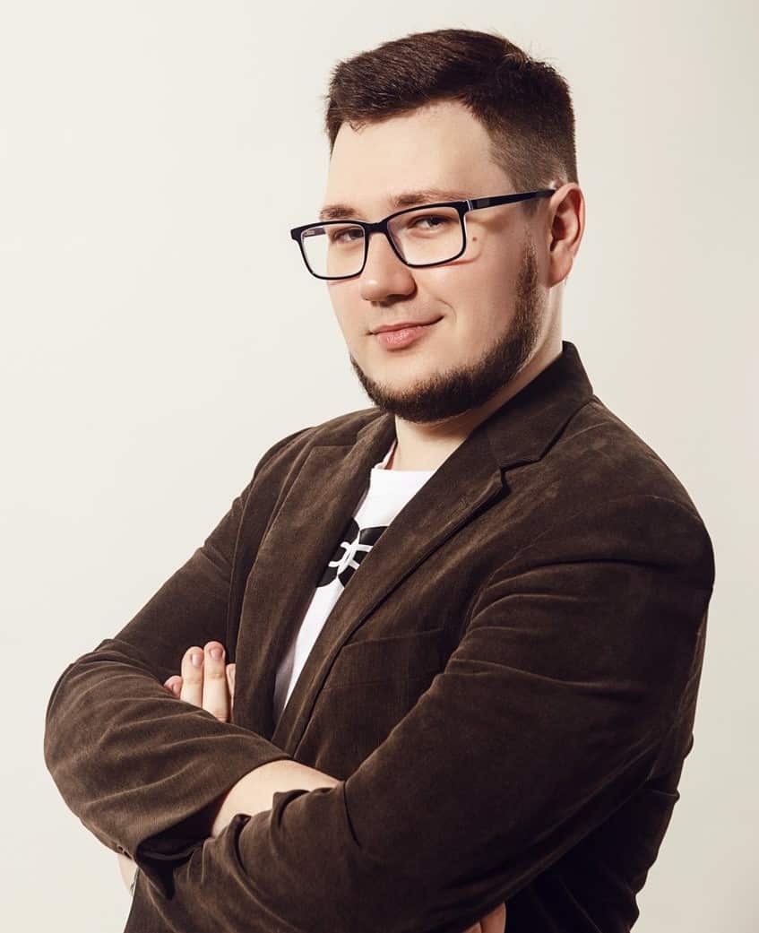 Hate crime monitor Vitalii Tsariuk standing with arms folded.