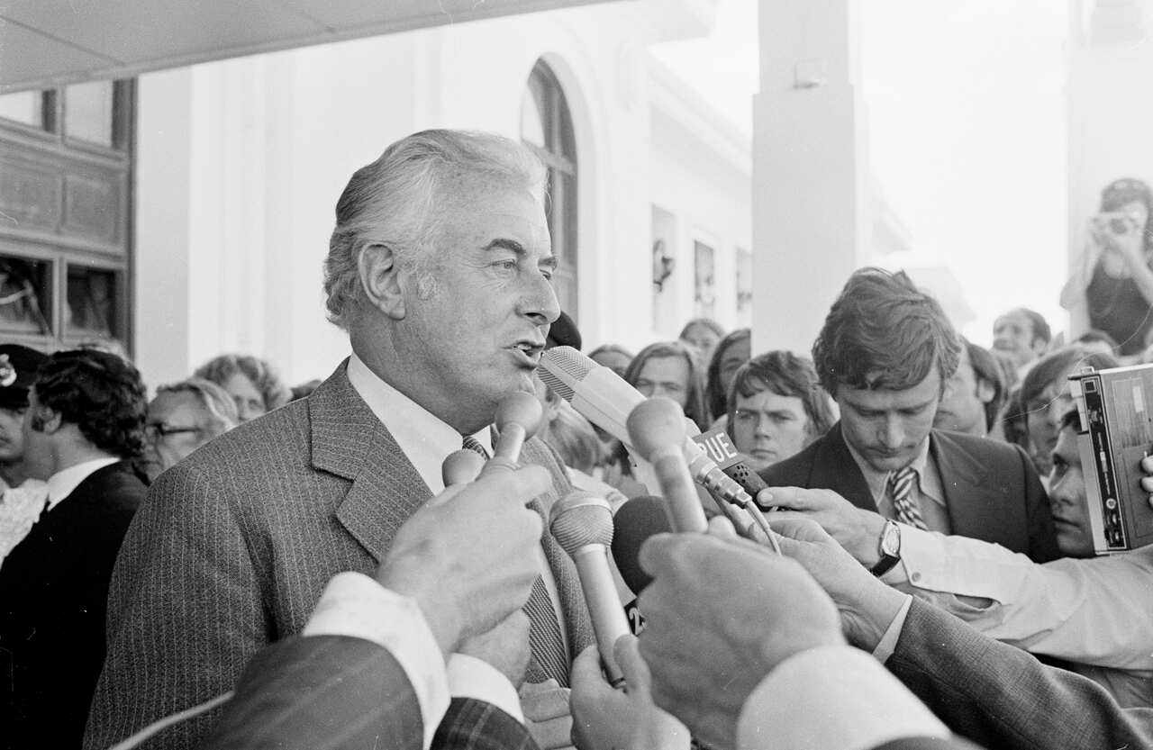 People hold microphones in front of Gough Whitlam on the steps of Parliament House following his dismissal as Prime Minister in 1975  
