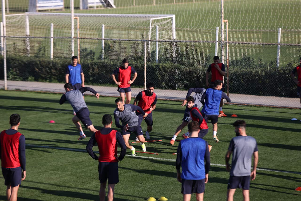 Male footballers training on a green pitch