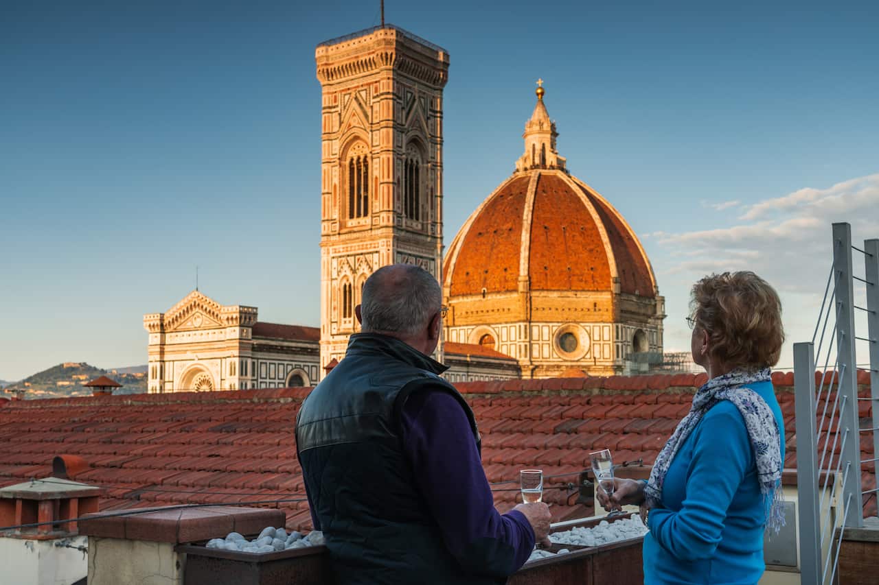 A couple enjoys prosecco and the sight of the Duomo in Florence.