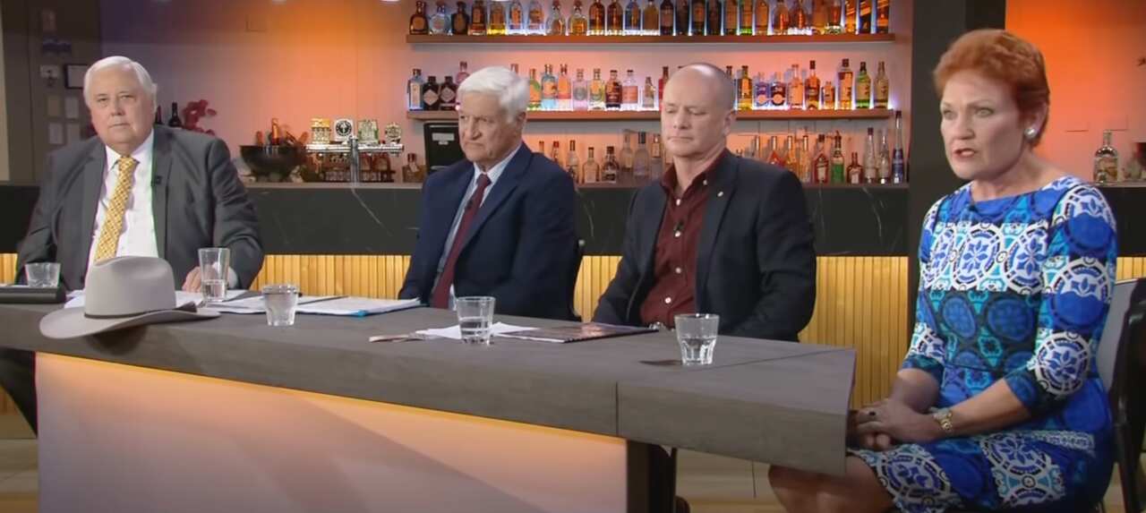 Three men and a women, seated behind a table.