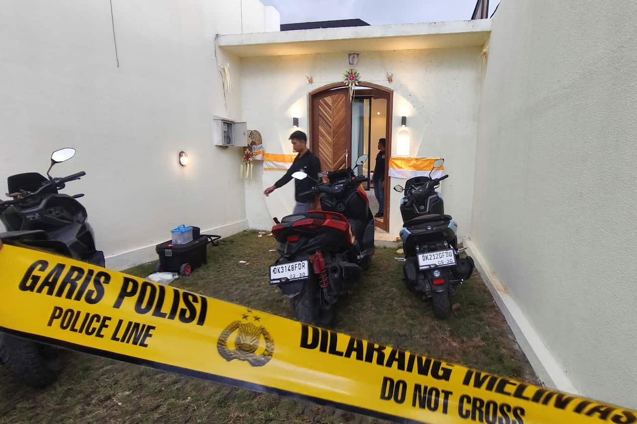 Scooters outside an Indonesian villa with yellow police tape out the front