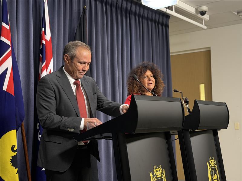A man and a woman standing behind a lectern 