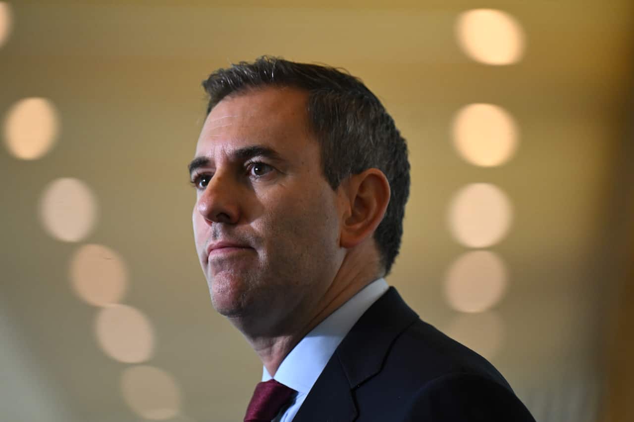 Treasurer Jim Chalmers wearing a black suit and red tie.