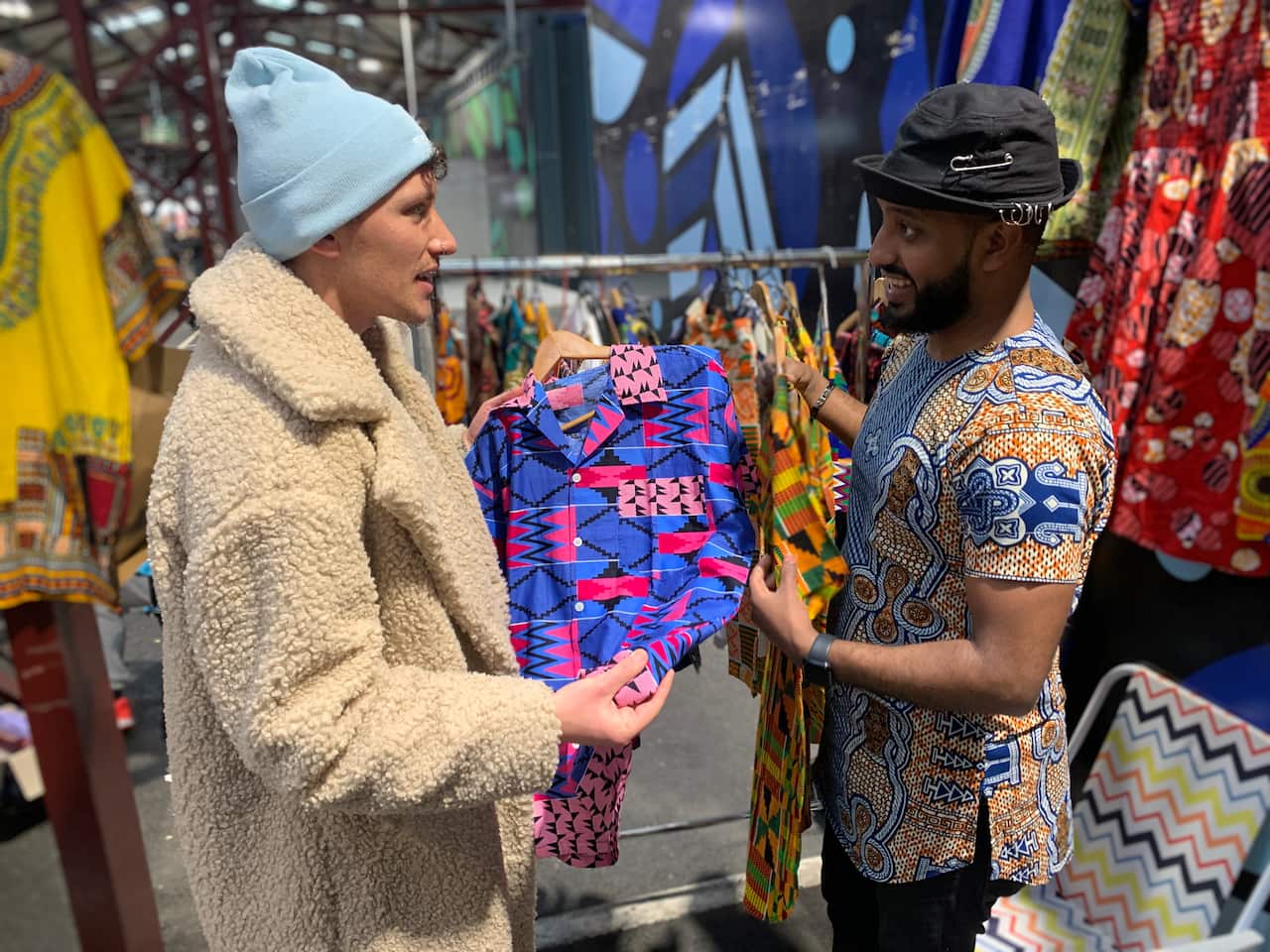 Salhe Siraj (right) with a customer at his market stall