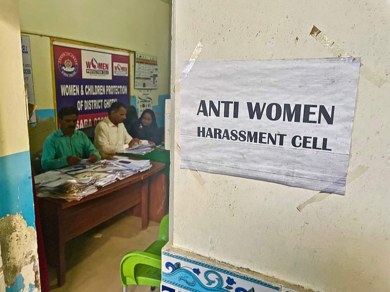 A sign stuck on a wall reads: Anti women harrassment cell