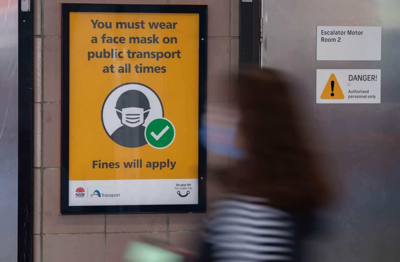 A mask-on notice is seen at a train station in Sydney, Australia, on 27 July, 2022.
