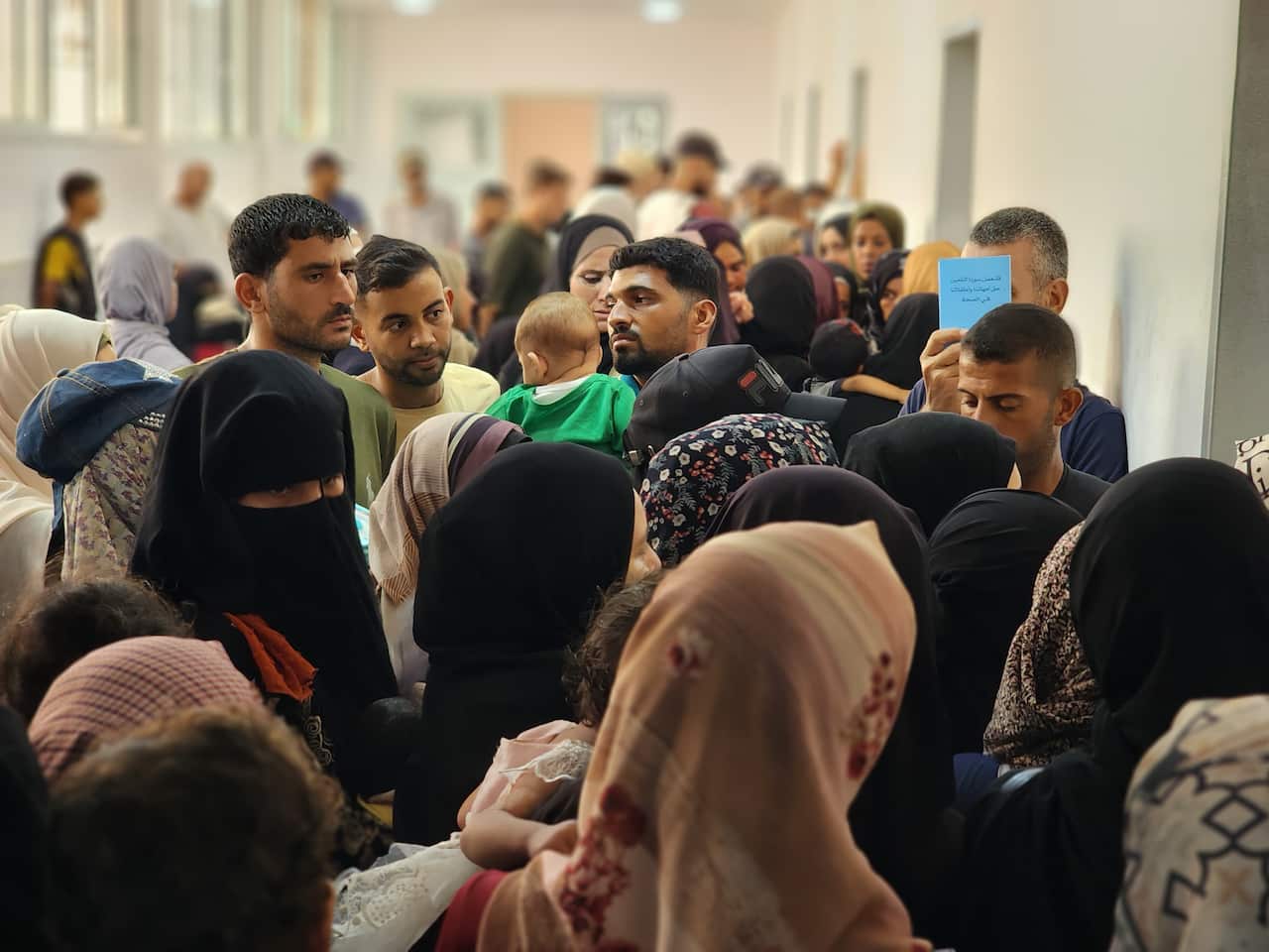A crowd of families wait to have their children receive a vaccine in Gaza.