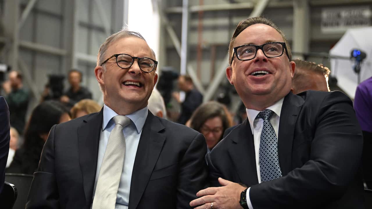 Anthony Albanese and Alan Joyce sitting next to each other and smiling.