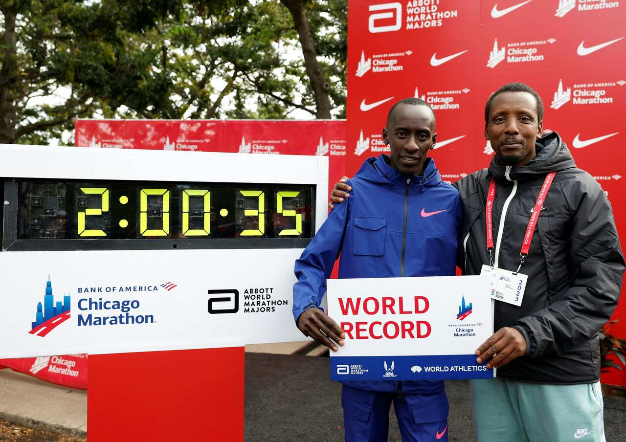Two men posing for a photo. They are holding a sign that reads "World Record".