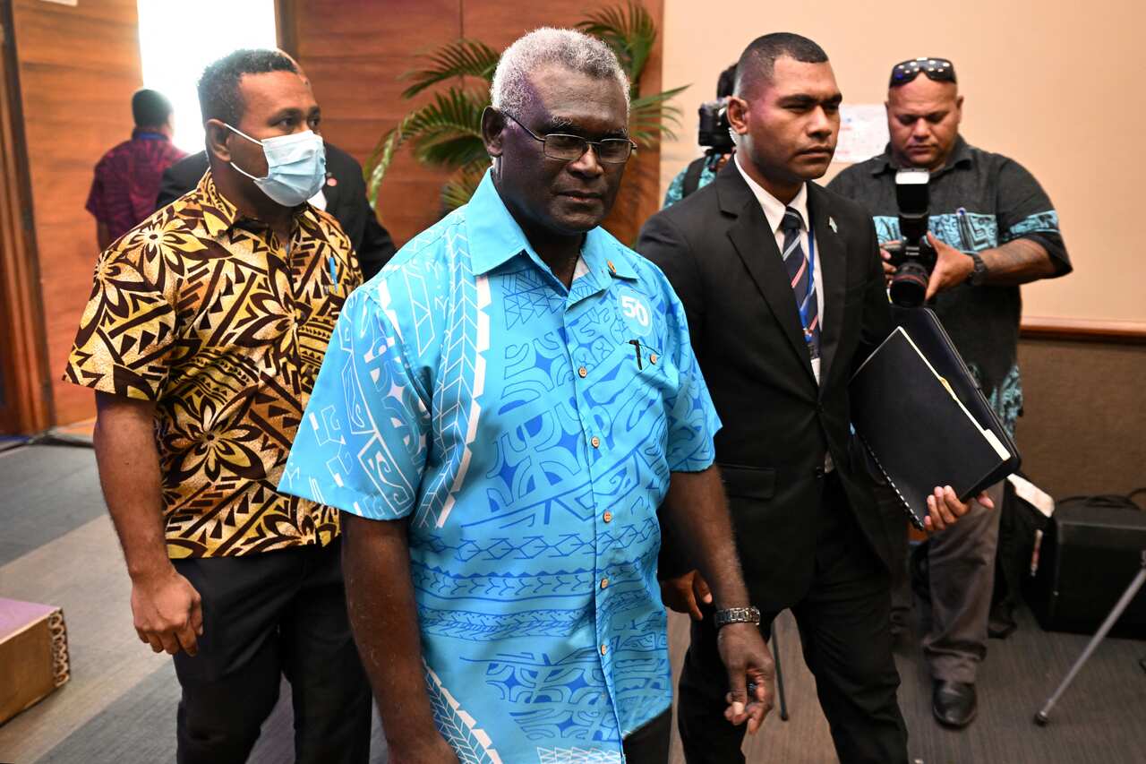 Prime minister of the Solomon Island Manasseh Sogavare walking through a room.
