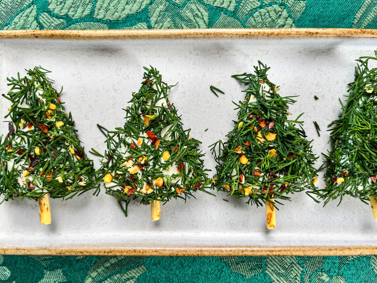 A row of cream cheese decorated to look like little Christmas trees
