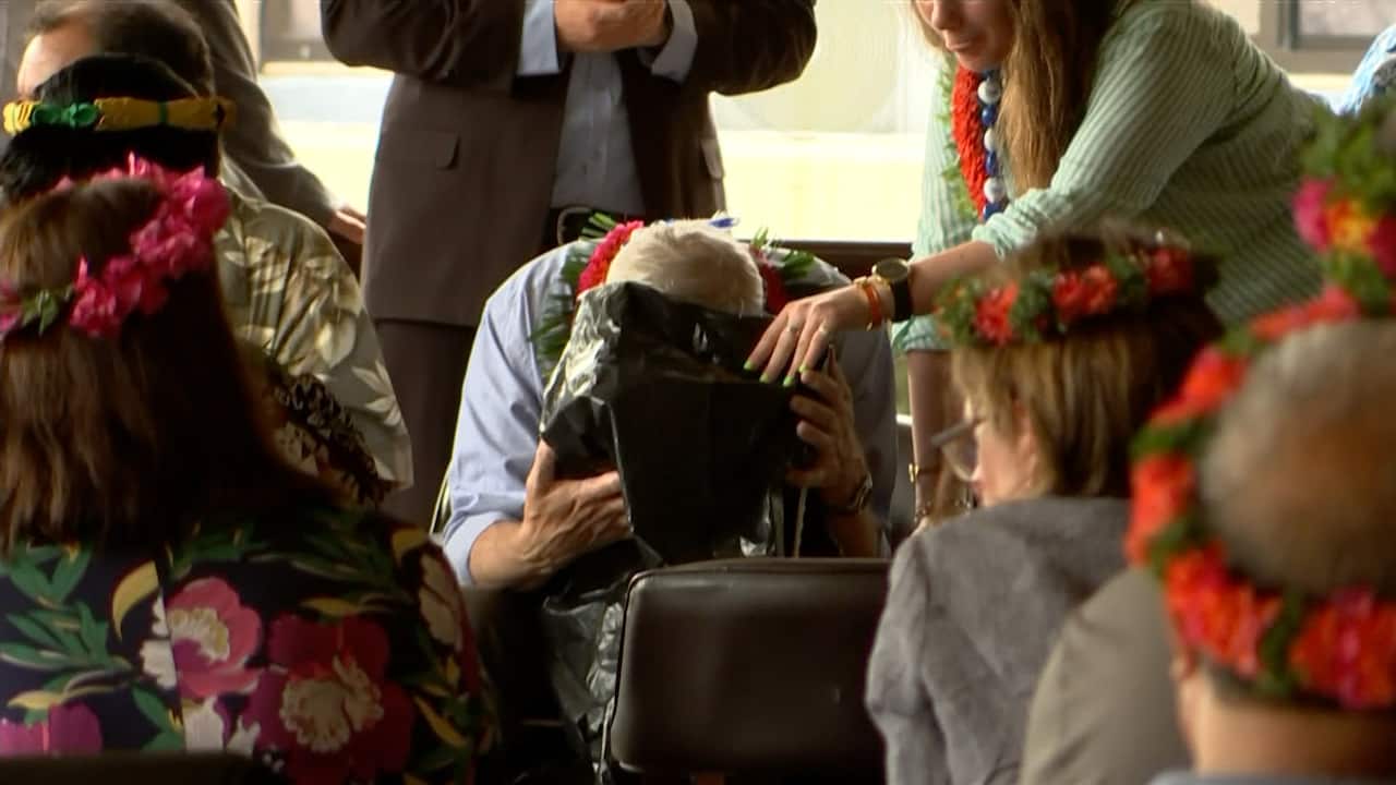 A man with his head down a bucket. 