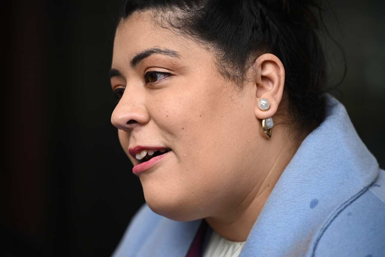 a close up of a woman's face, wearing a powder blue blazer