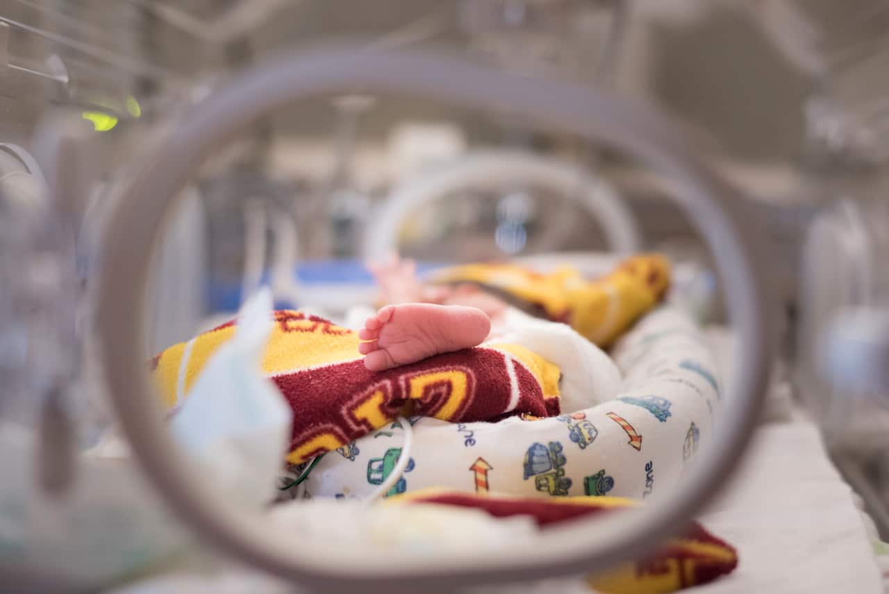 Looking into a NICU crib at the foot of a premature baby's foot. 