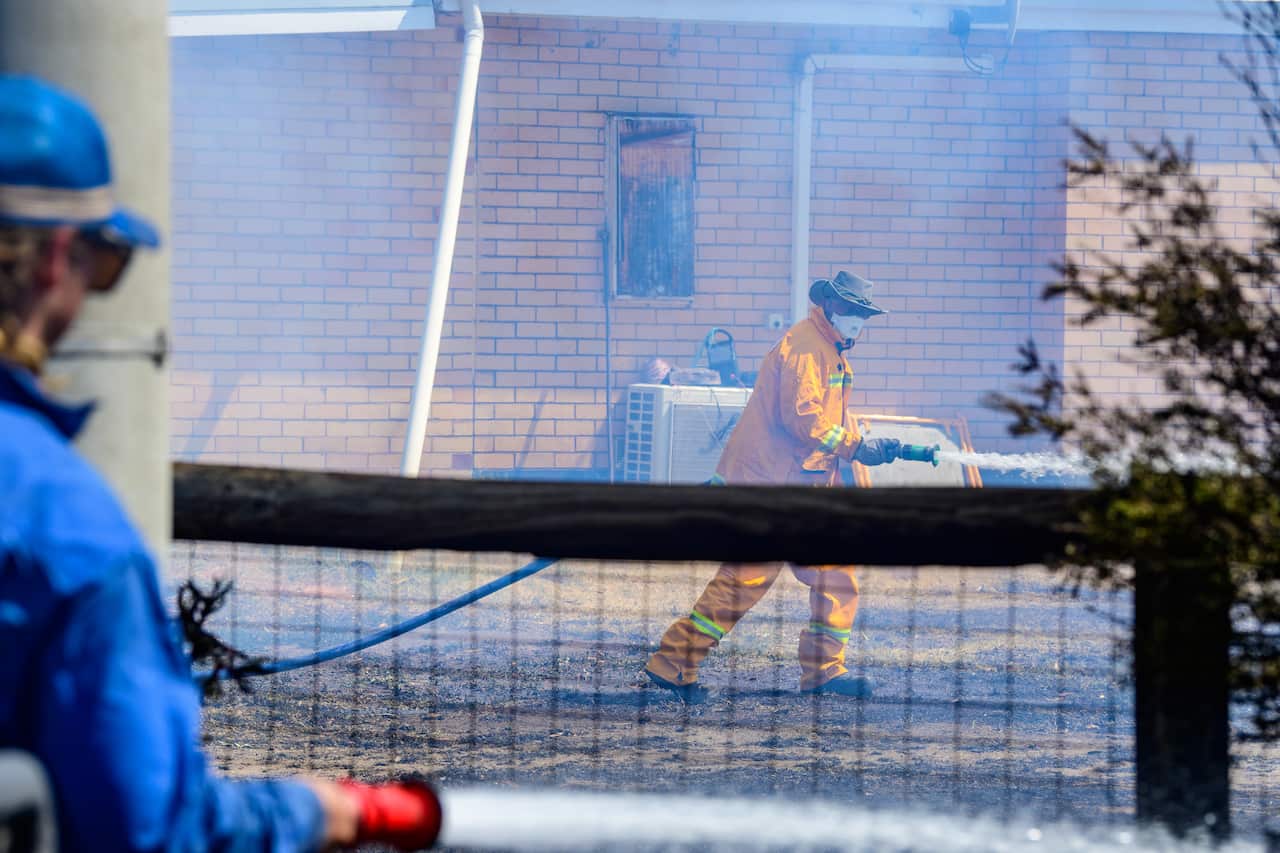 Country Fire Authority members douse a home at Longwood.