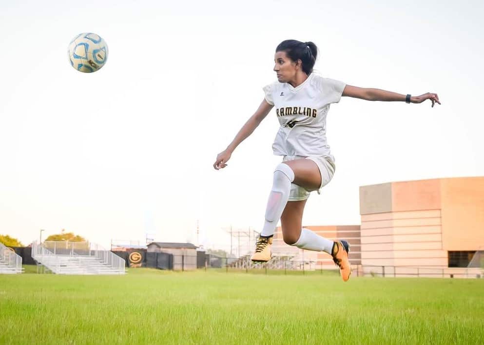 Priya mid-air playing soccer in the USA.