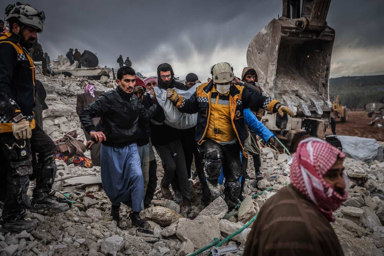 Rescuers carrying a survivor through the rubble