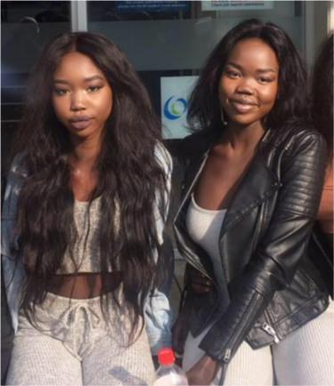 Two girls with long black hair sit side by side.