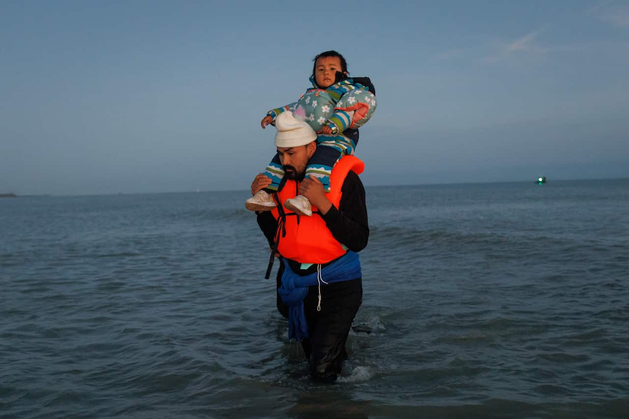 Man stands in water with a child on his shoulders