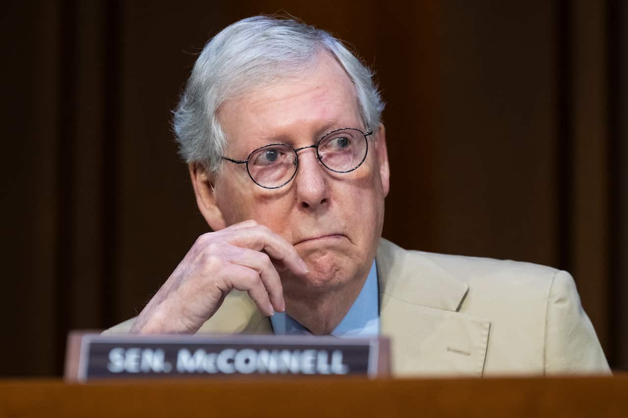 A man sitting down, listening.