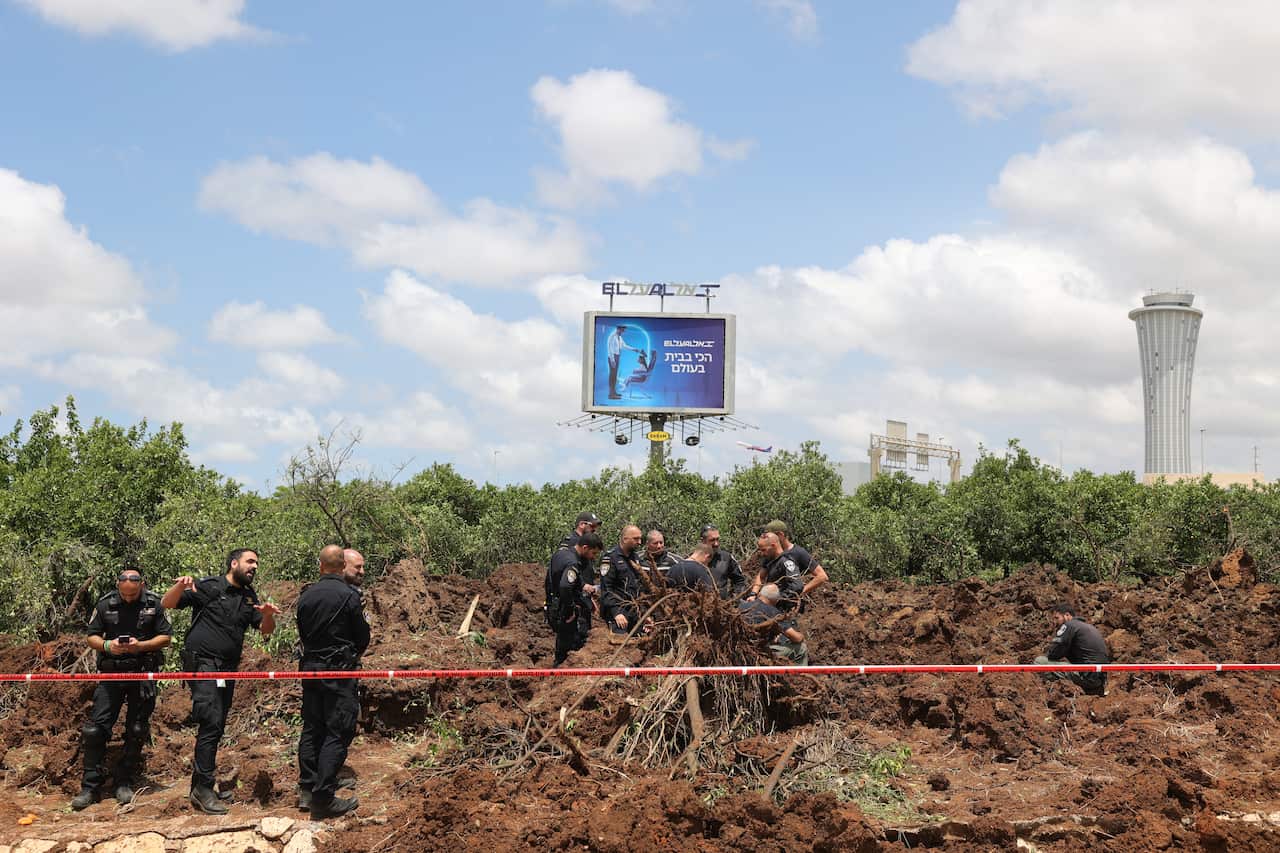 A group of police officers inspect the blast site.
