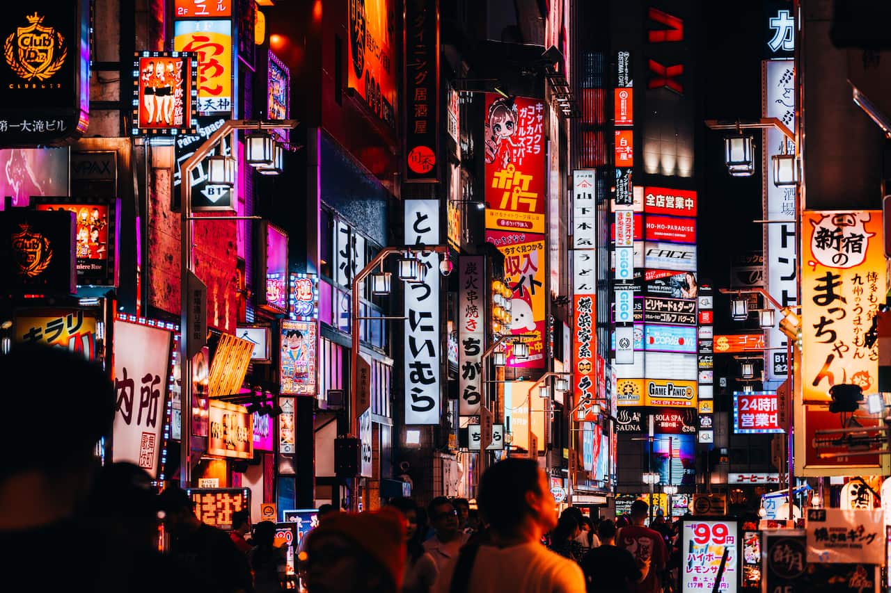 Bright signs and lights in a busy city street.