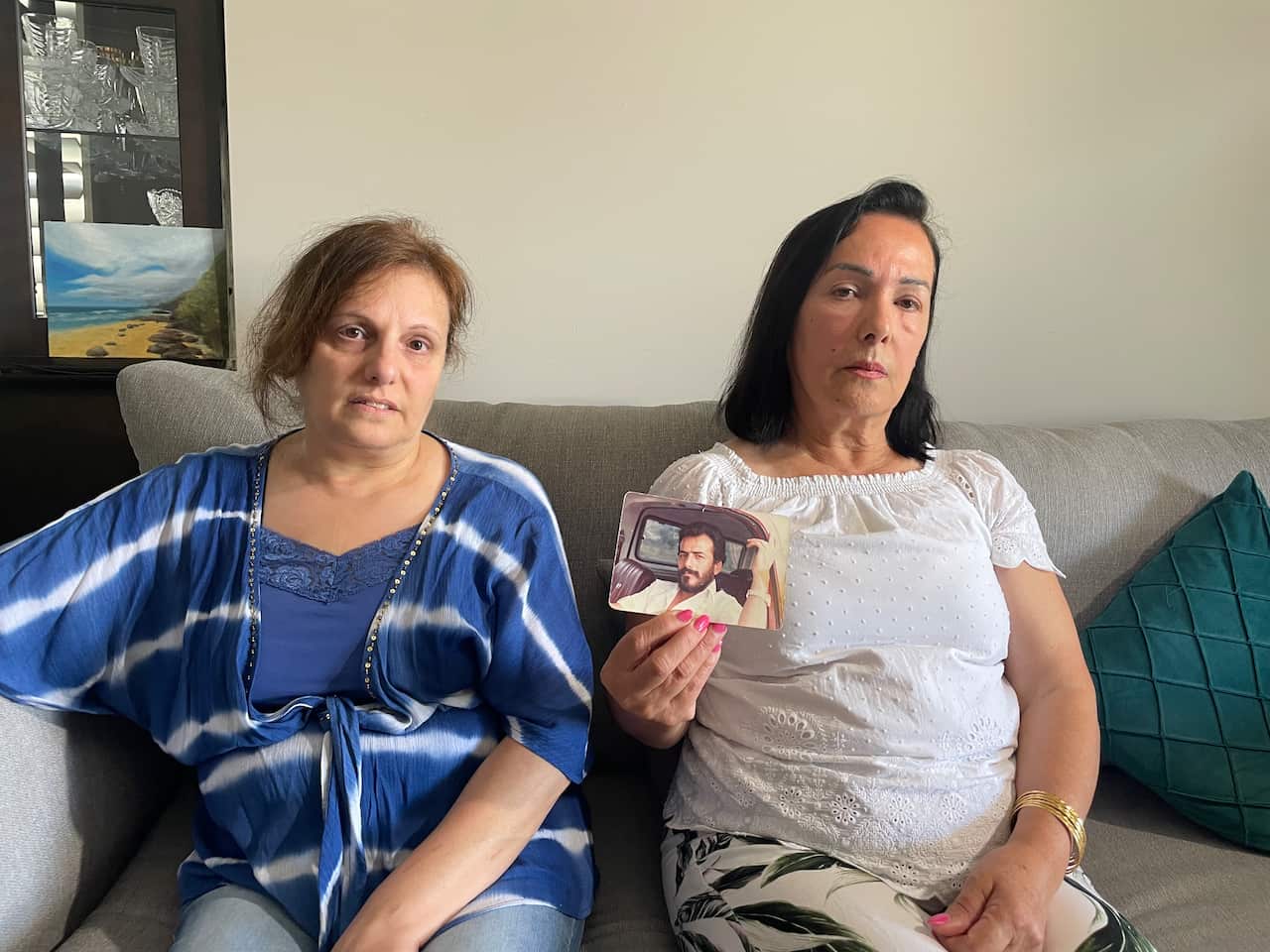 Adel Al Deeb's family holding a photograph of him