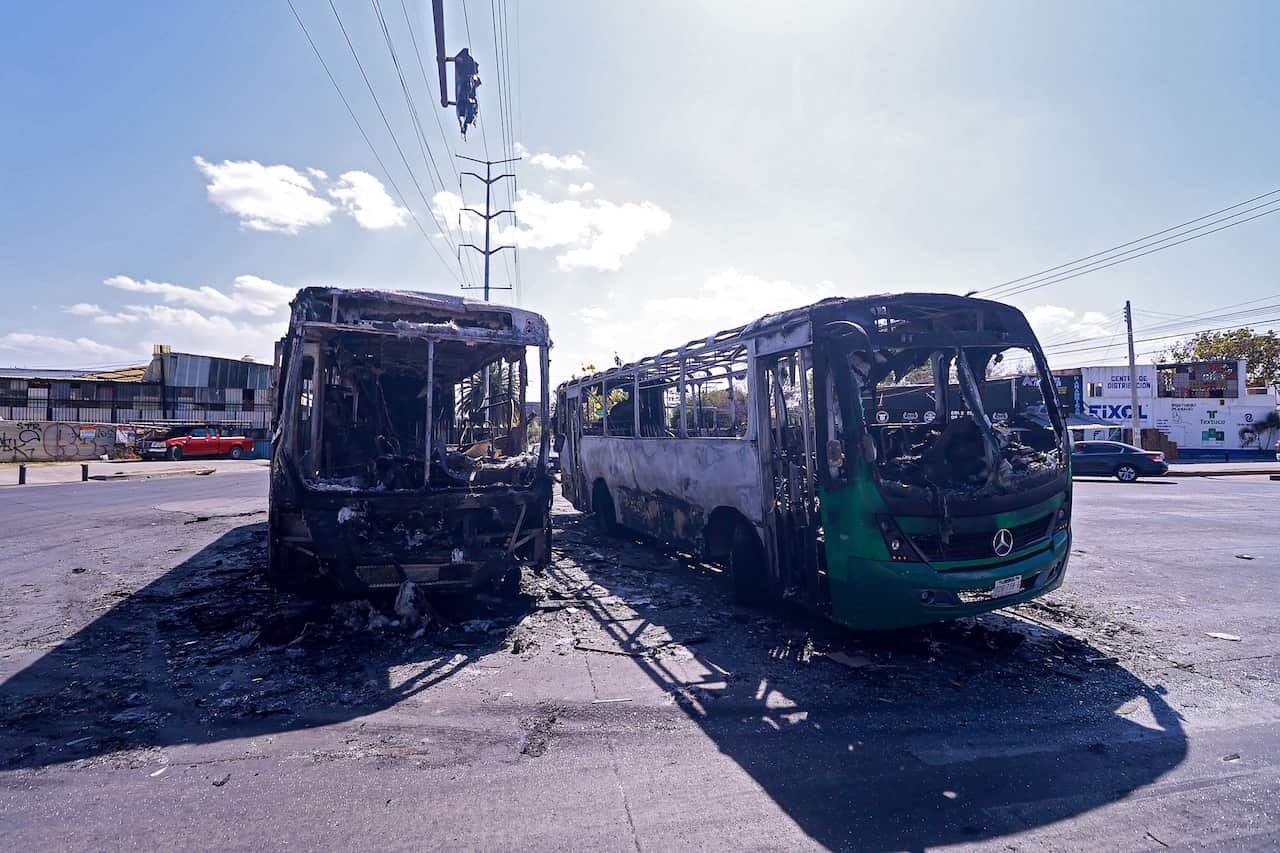 Burnt out buses on a street in Zapopan.