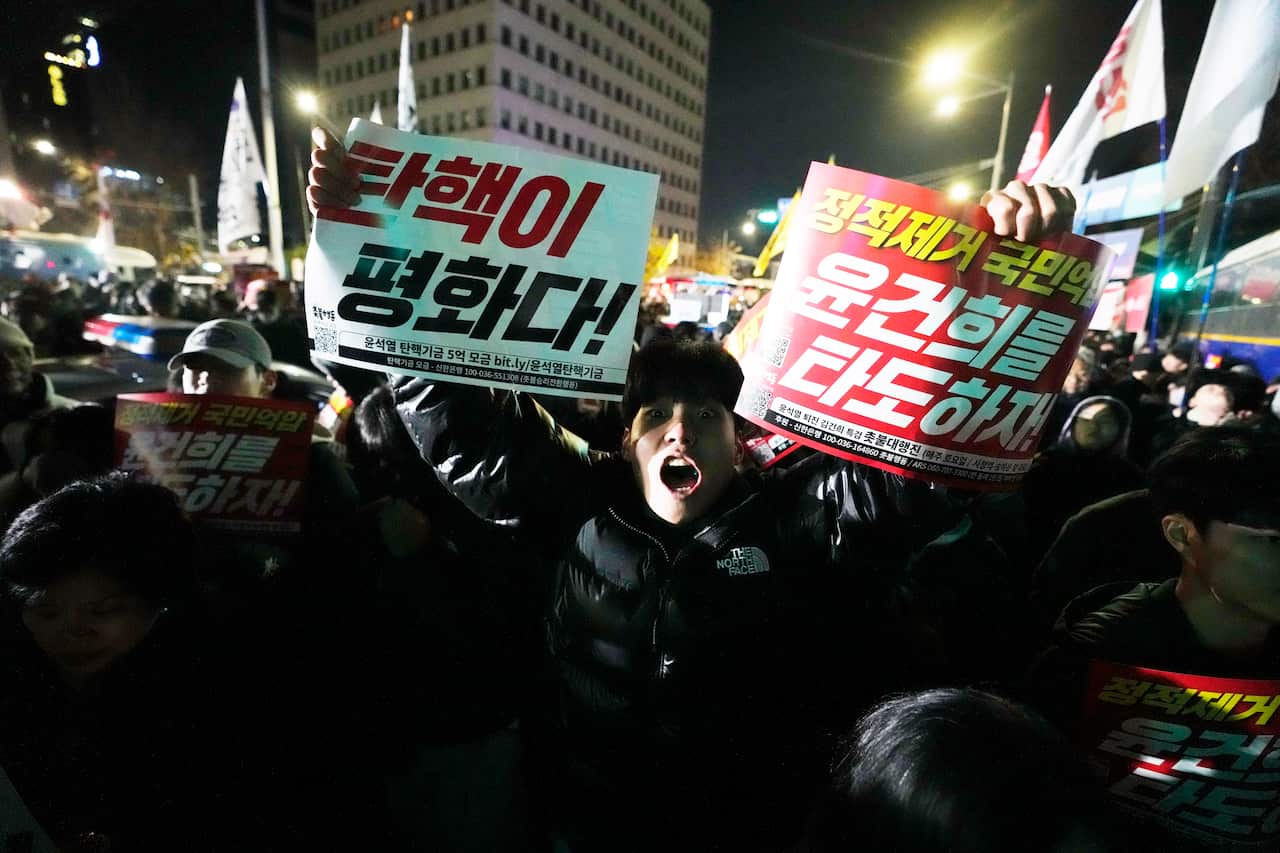 Protesters holding up signs in Korean.