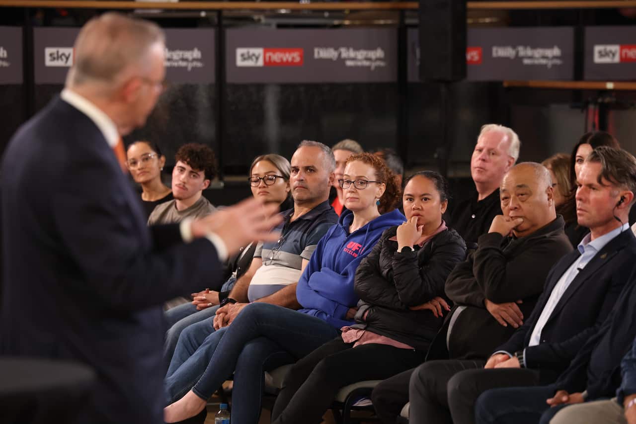 Anthony Albanese gestures with his hands as he speaks, with members of the audience seated in front of him.