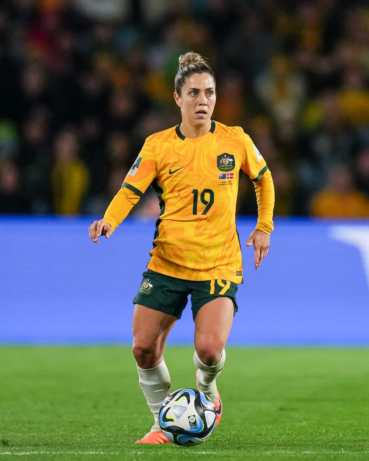 A woman in a longsleeve yellow football shirt