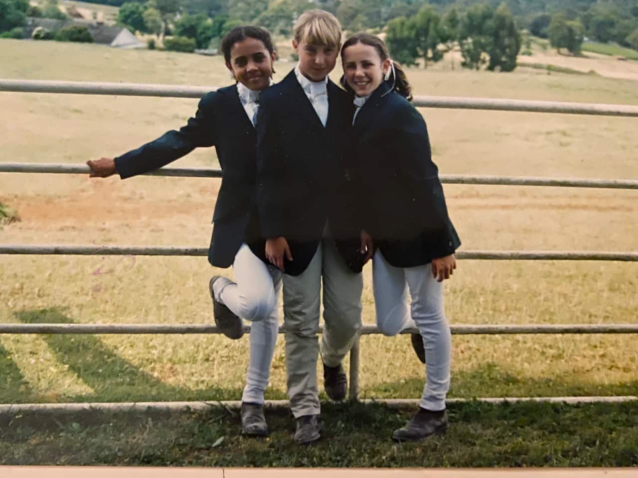 Three young girls in horse riding attire