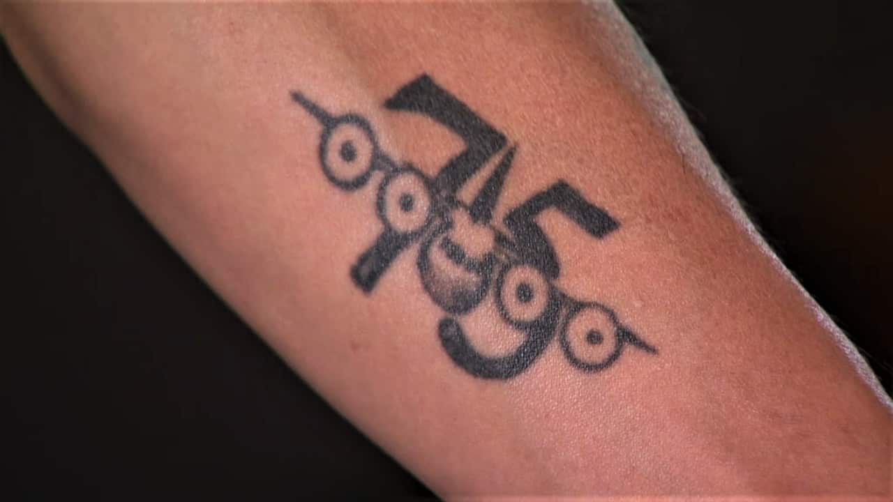 A close up of a forearm with a black tattoo of the number 75 with the outline of a RAAF aircraft over the top.