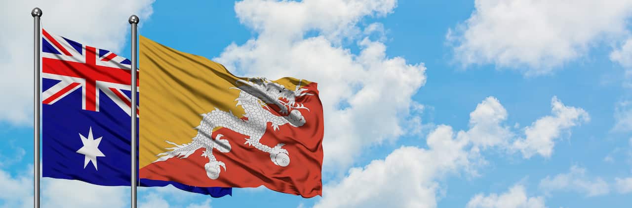 Australia and Bhutan flag waving in the wind against white cloudy blue sky together. Diplomacy concept, international relations.