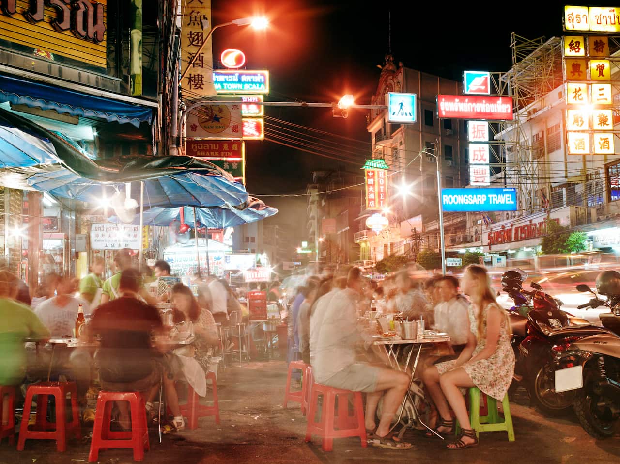 People dining outside at food stalls at night