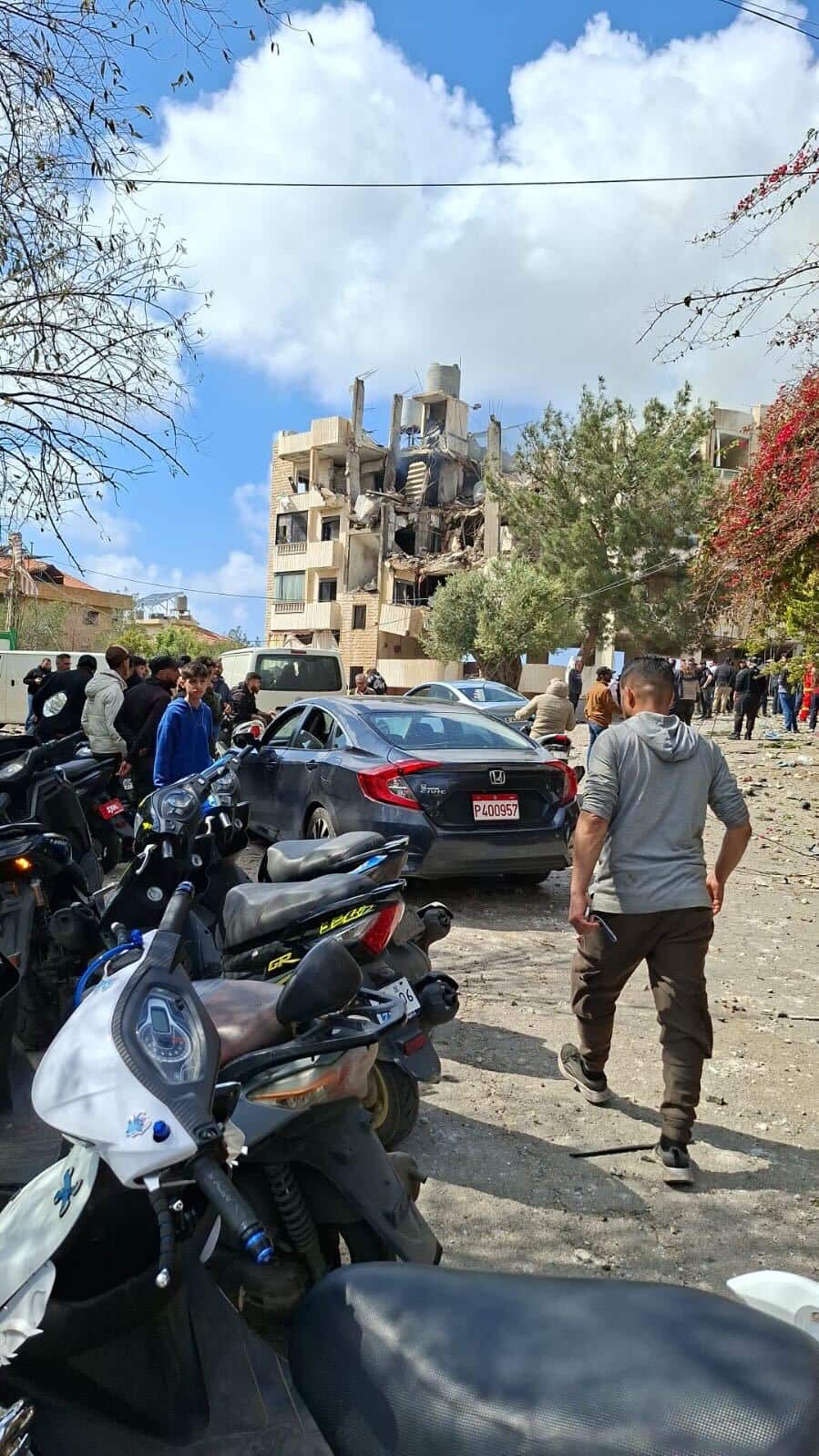 People outside near a bombed unit block