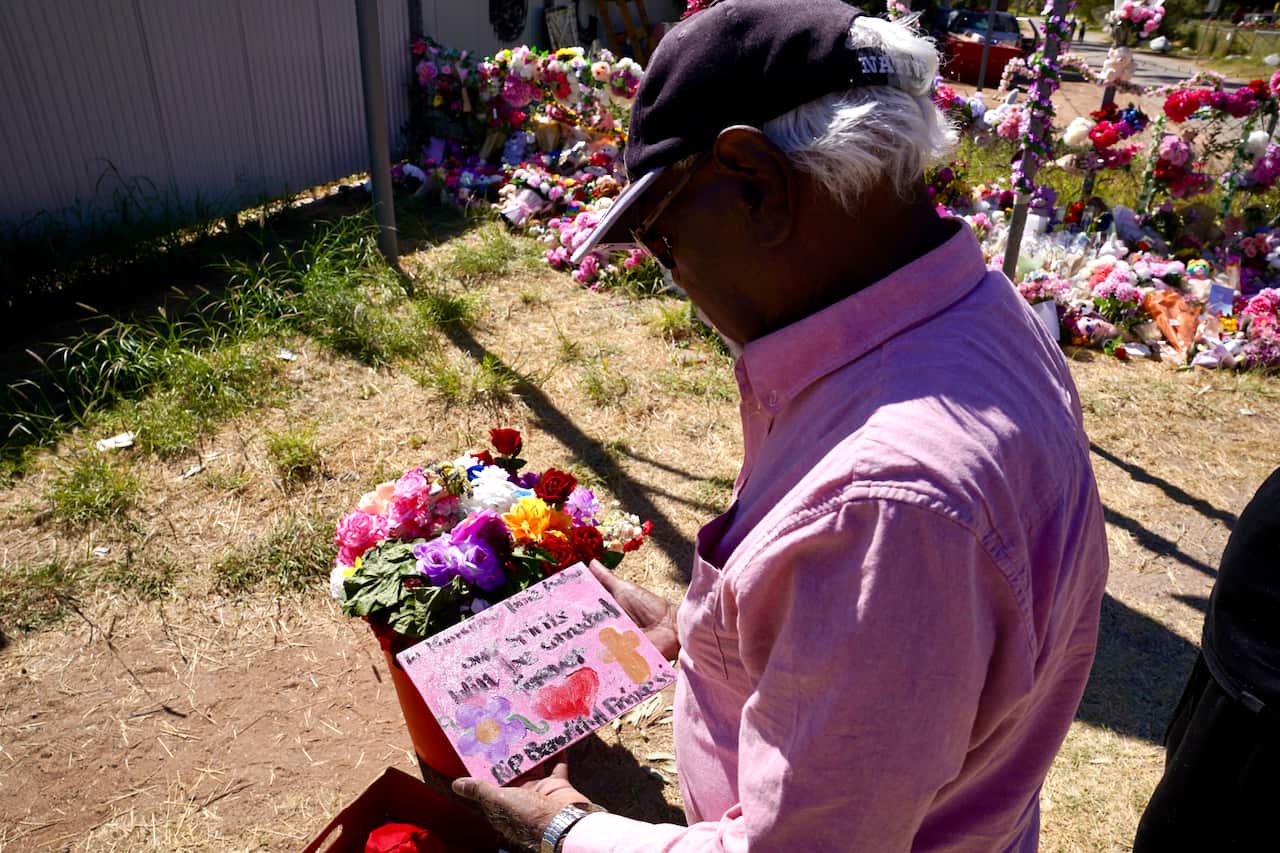 A man in a pink shirt looks down at a pink card