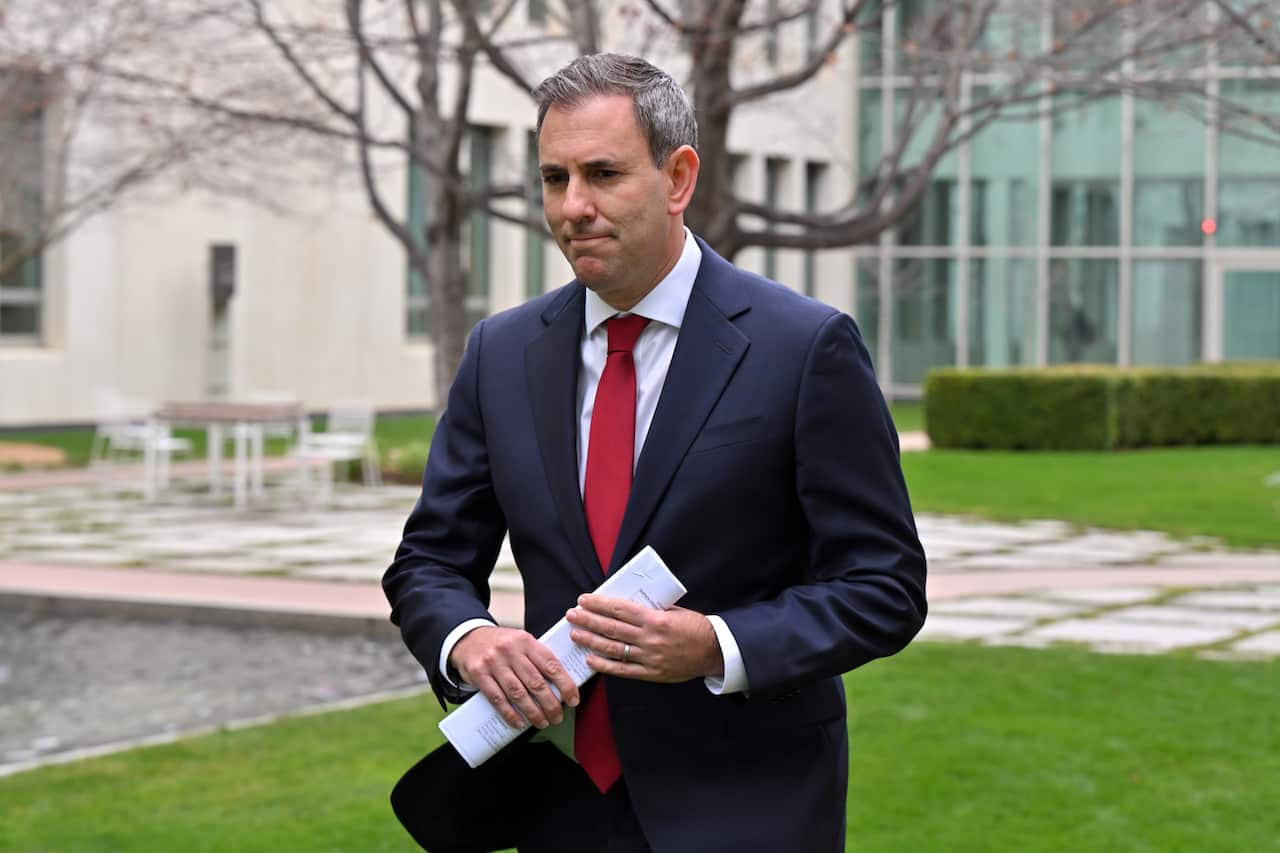 Jim Chalmers in a dark suit and red tie outside