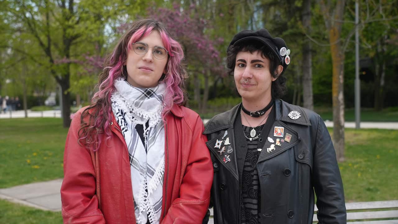 Una mujer más joven y un transexual más joven están uno al lado del otro en un parque.