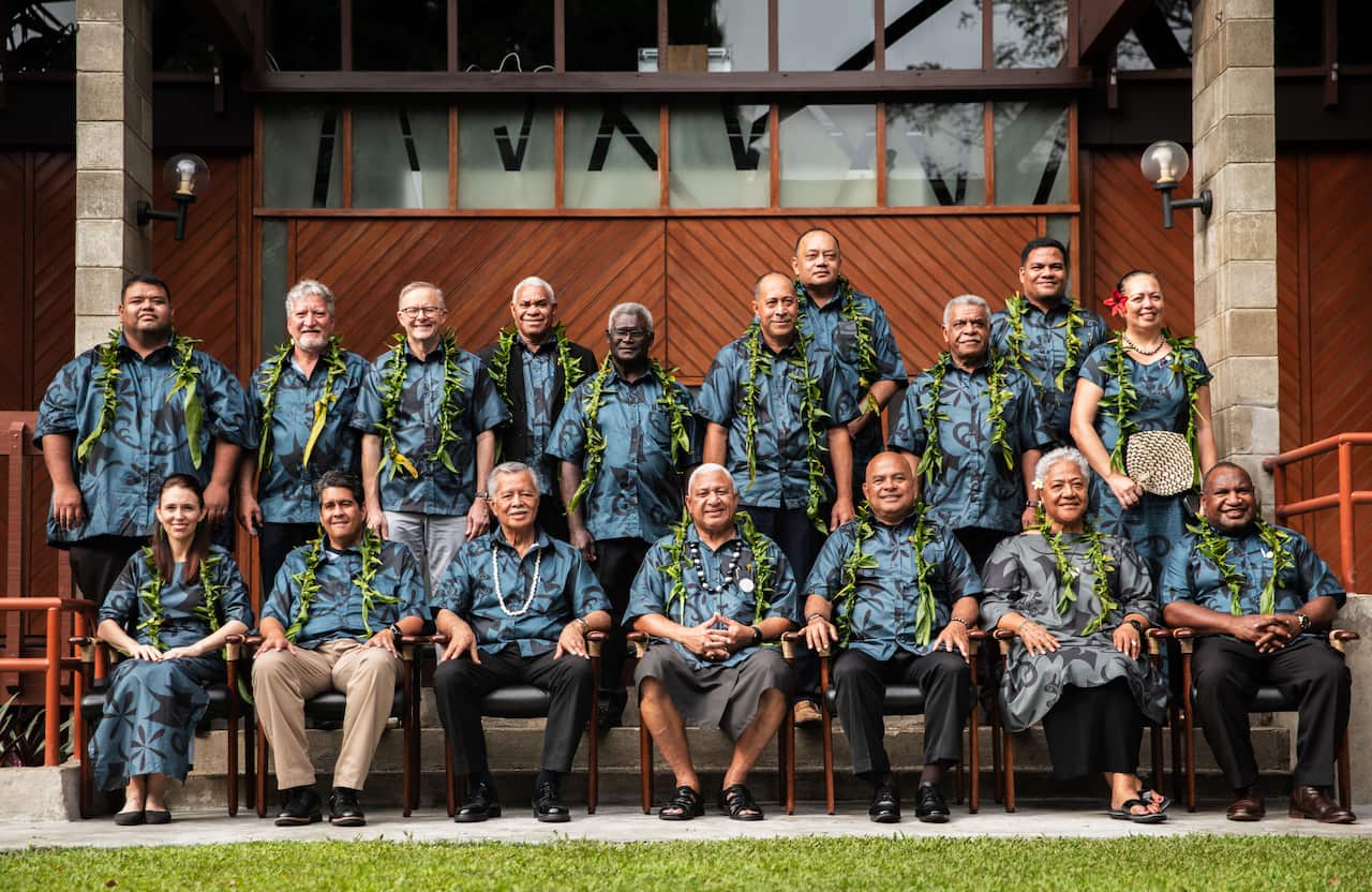 Pacific leaders pose for a photo, wearing matching shirts and dresses