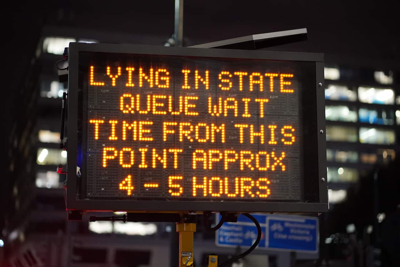 A sign indicates the waiting time for the queue to view Queen Elizabeth II lying-in-state.