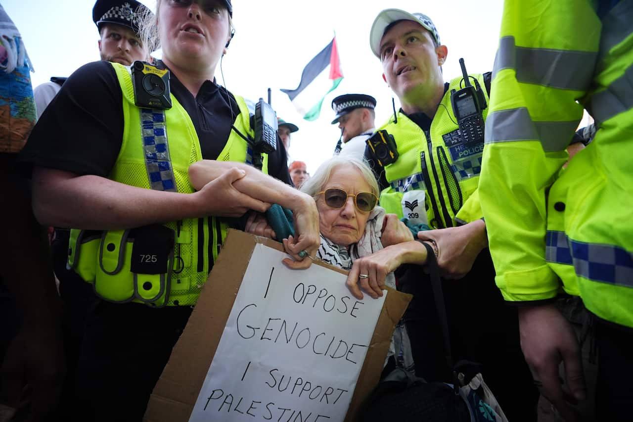 Police officers detain a protester as demonstrators take part in a Lift the Ban on Palestine Action protest